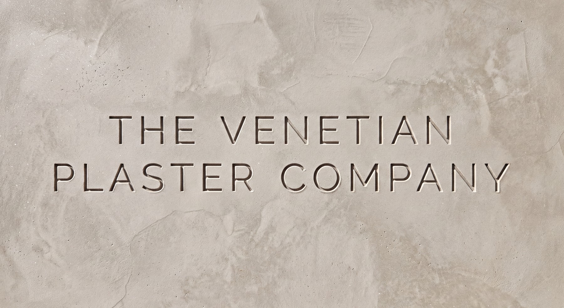 The Venetian Plaster Company name engraved into a hand-trowelled plaster plaque